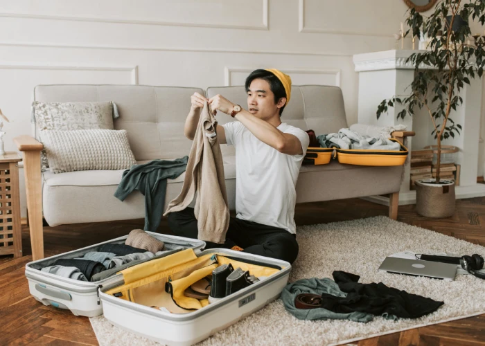 an asian man wearing a white tshort doing some preparation packing