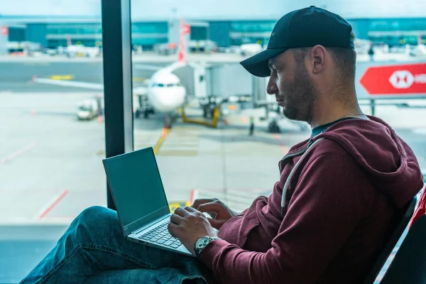 man using a laptop sitting in the airport